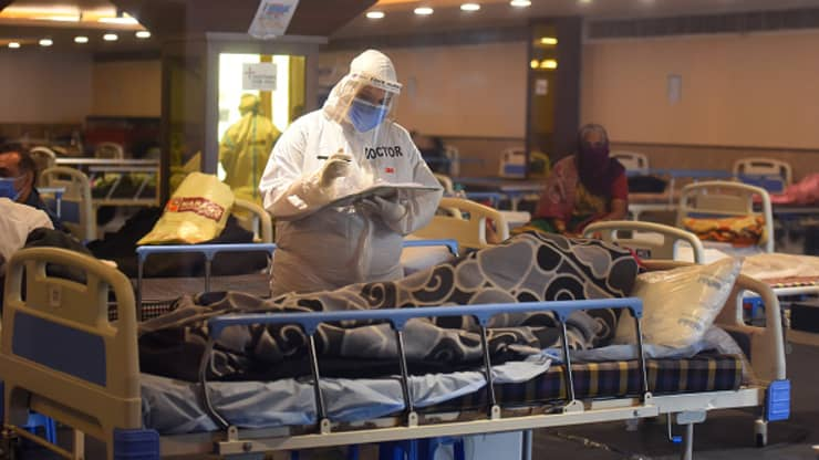 Medical staff in PPE attending to a person in the temporary Covid-19 care centre attached to LNJP Hospital, at Shehnai Banquet Hall, on April 23, 2021 in New Delhi, India.