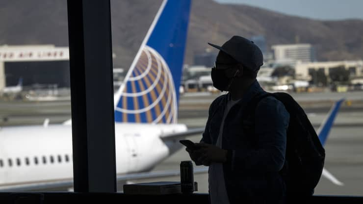 A traveler wearing a protective mask waits to board a United Airlines Holdings Inc. flight at San Francisco International Airport (SFO) in San Francisco, California, Oct. 15, 2020. U