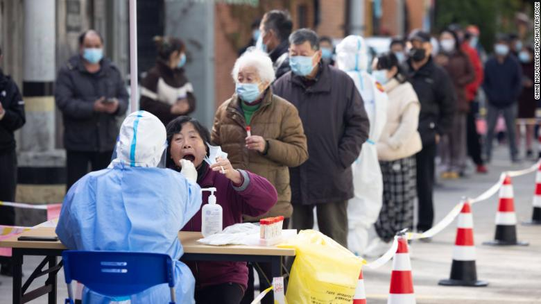 A medical worker takes a swab sample from a woman for nucleic acid test in Changning District of Shanghai on April 1, 2022. 