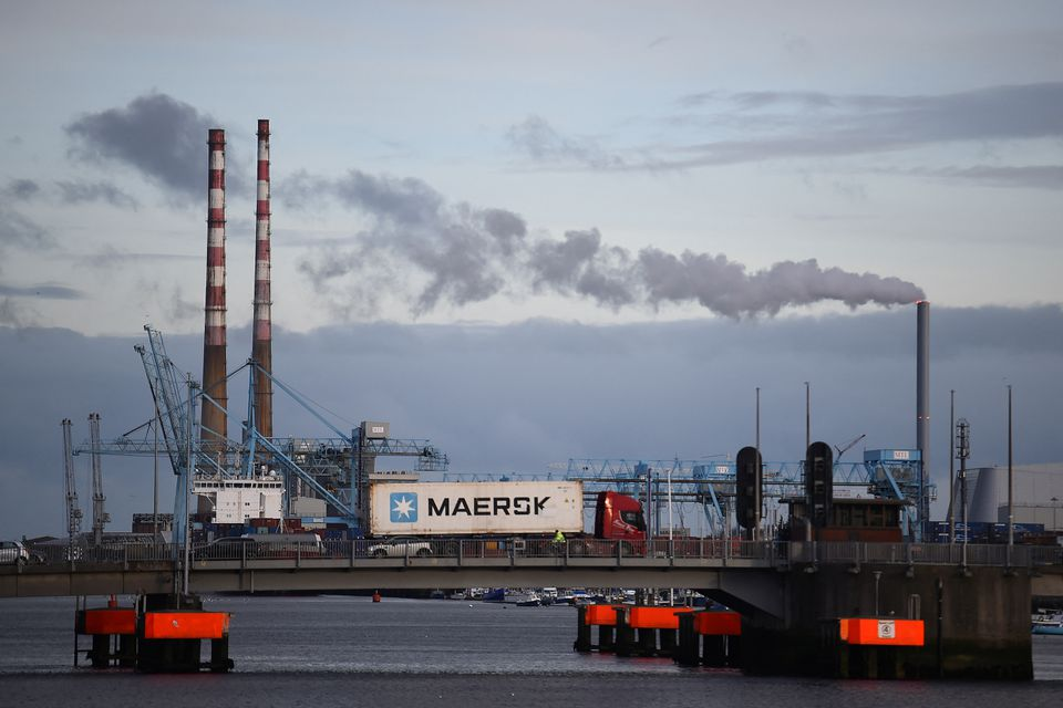 Truck driving a Maersk shipping container drives past Poolbeg Generating Station, in Dublin