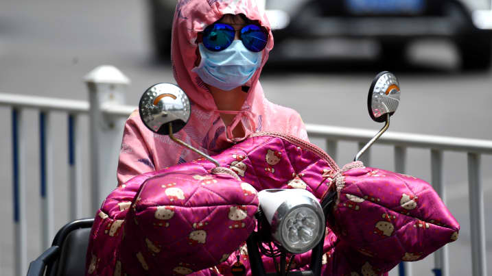 A citizen wearing a breathing mask to escape heat rides on the road on May 23, 2019 in China. The electricity load in the Chinese province of Henan reached a new record on Monday, primarily driven by air-conditioning demand, as scorching heat waves spread across regions north of the Yangtze river.