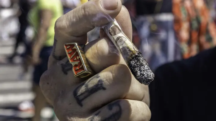 A man smokes marijuana during a hip-hop performance at the 11th annual block party held by the Bushwick Collective in Brooklyn, New York, on June 4, 2022.