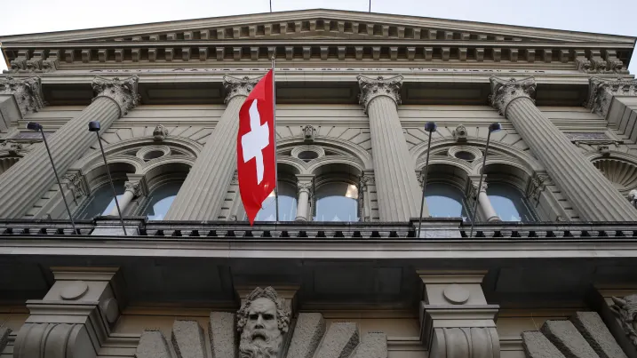 The Swiss national flag hangs from the Federal Palace, Switzerland's parliament building, in Bern, Switzerland. The Swiss National Bank has reported a record loss for 2022.