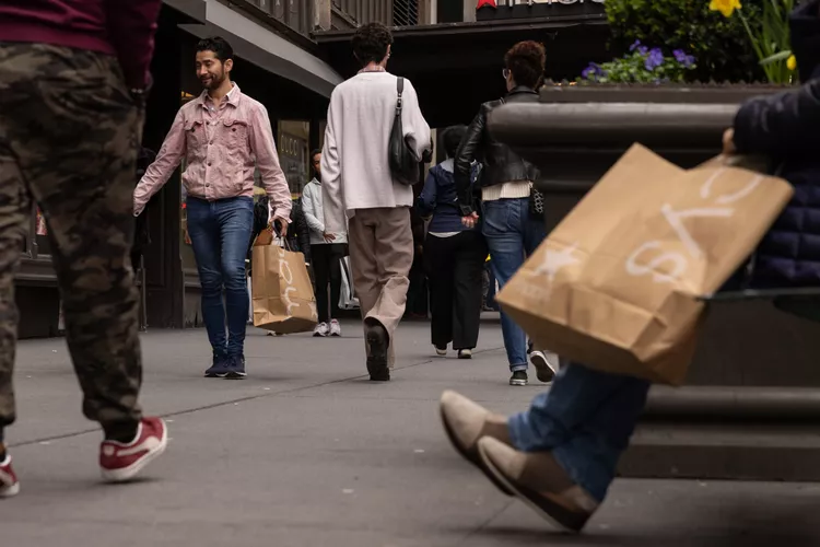 Shoppers carry Macy's bags outside the company's flagship store in the Herald Square neighborhood of New York, US, on Thursday, April 11, 2024.